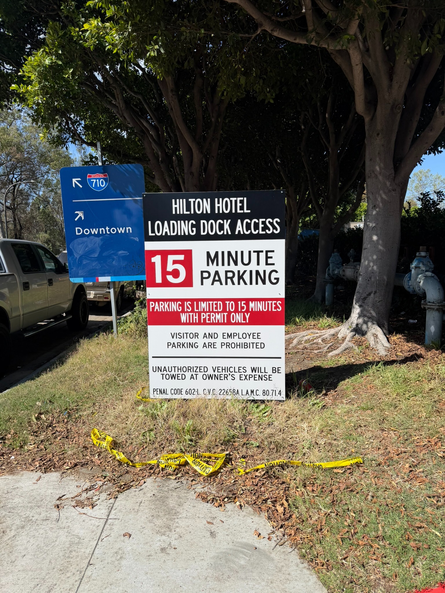 Black, white and red loading dock access sign identifying 15-minute permit parking and parking restrictions